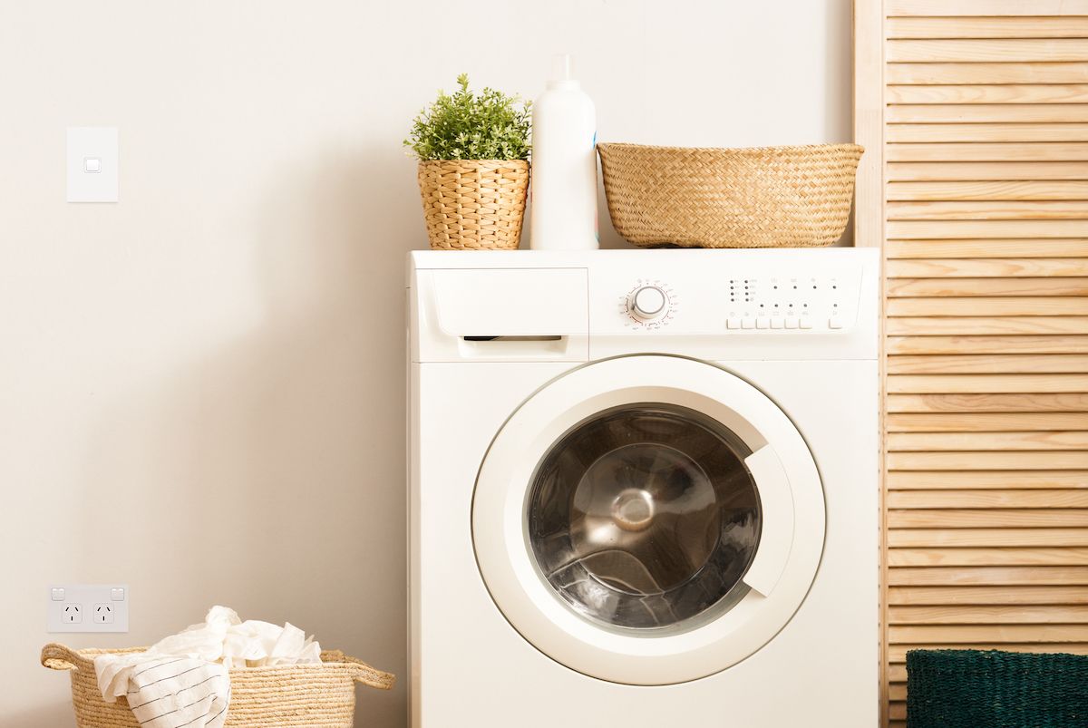 laundry room with washing machine and switch and outlet on wall