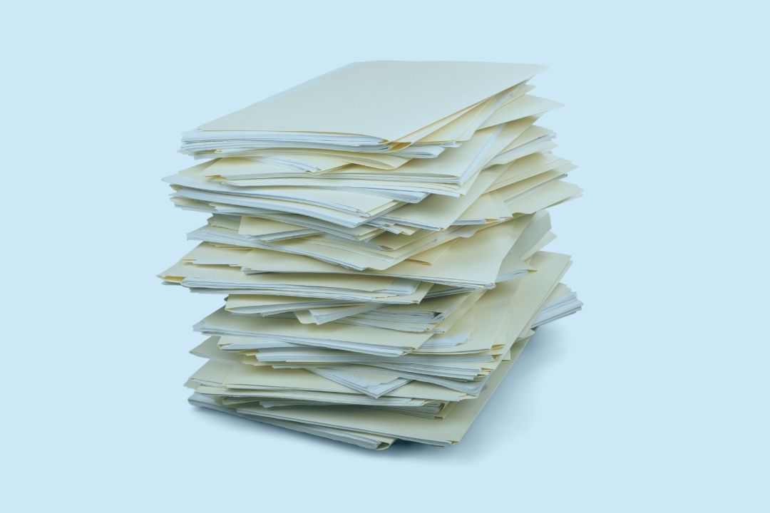 A stack of files with documents in them