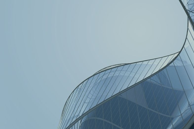 The image is a stock photo of a modern, curved glass building, often used for architectural or business-related backgrounds.